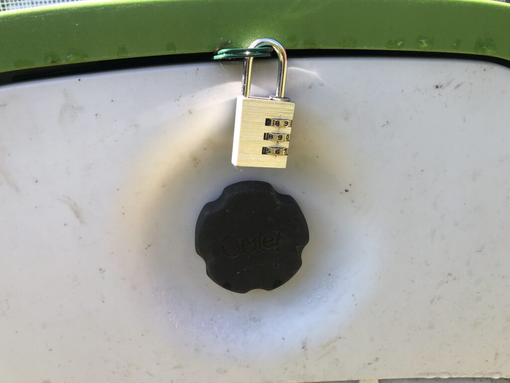 Image shows Eglu Go security bracket with a combination padlock keeping it shut.